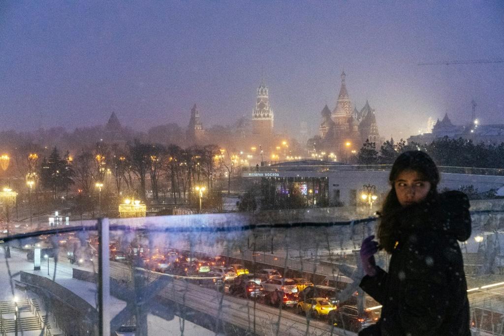 A girl overlooks a light dusting of snow in Moscow, 30 December 2019. Known for its cold winters, Moscow saw its warmest December in a century in 2019. Photo: Dimitar Dilkoff / AFP