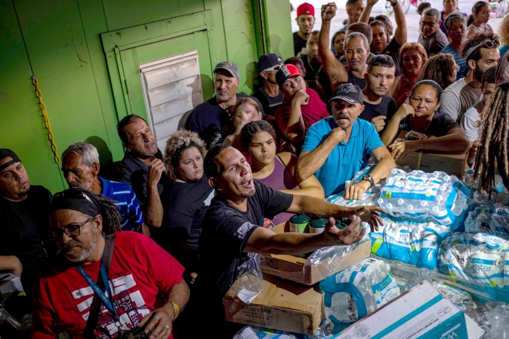 People break into a warehouse with supplies believed to have been from when Hurricane Maria struck the island in 2017 in Ponce, Puerto Rico on 18 January 2020, after a powerful earthquake hit the island. Photo: Ricardo Arduengo / AFP / Getty Images