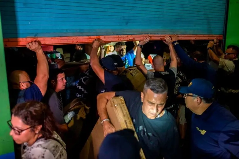 People break into a warehouse with supplies believed to have been from when Hurricane Maria struck the island in 2017 in Ponce, Puerto Rico on 18 January 2020, after a powerful earthquake hit the island. Photo: Ricardo Arduengo / AFP / Getty Images