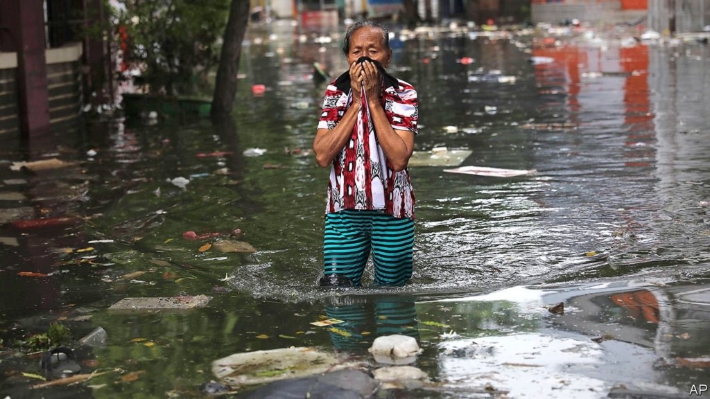 A woman reacts as she wades through flood water in Jakarta on 4 January 2020. Photo: AP