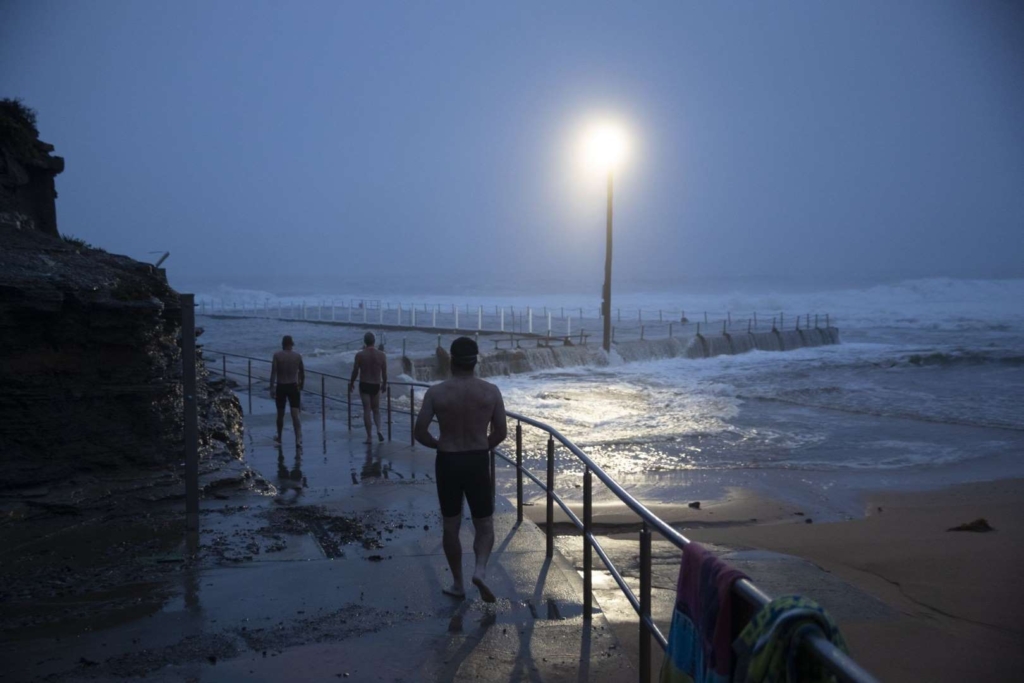 Swimmers observe beach erosion is seen at Collaroy on the Northern Beaches as a high tide and large waves impact the coast on 10 February  2020 in Sydney, Australia. The Sydney area experienced its wettest weekend in more than 20 years, with strong winds and torrential rain causing flash flooding across the city. Photo: Brook Mitchell / Getty Images