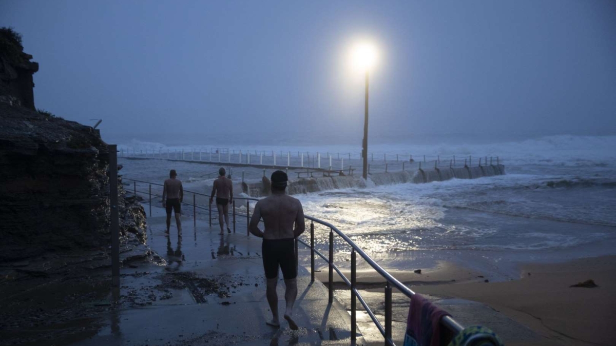 Swimmers observe beach erosion is seen at Collaroy on the Northern Beaches as a high tide and large waves impact the coast on 10 February 2020 in Sydney, Australia. The Sydney area experienced its wettest weekend in more than 20 years, with strong winds and torrential rain causing flash flooding across the city. Photo: Brook Mitchell / Getty Images