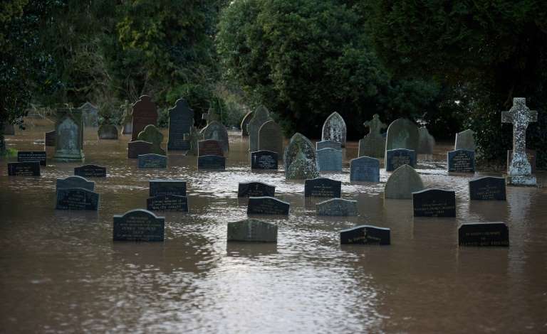 Flood water surrounds tomb stones at a graveyard in Tenbury Wells, after the River Teme burst its banks in western England, 16 February 2020. Photo: Oli Scarff