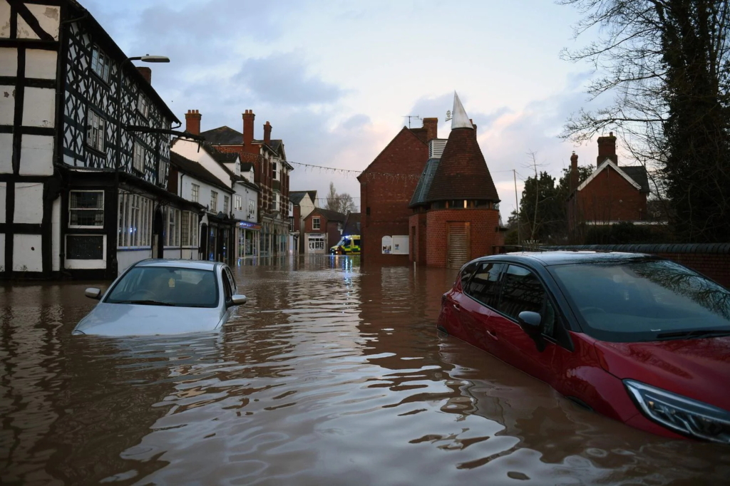 Floodwater surrounds abandoned cars in Tenbury Wells, in western England, after the River Teme burst its banks on Sunday, 16 February 2020. Photo: Oli Scarff / AFP / Getty Images