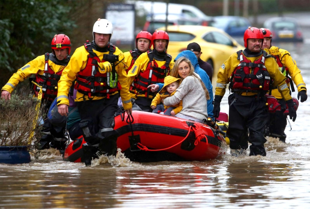 Members of emergency services evacuate residents from flooded houses by rescue boat in South Wales, on 16 February 2020. Photo: Geoff Caddick / AFP / Getty Images