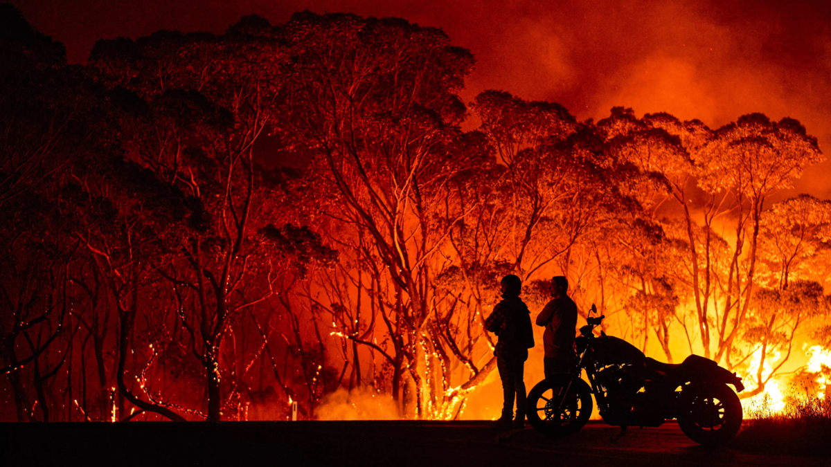 Residents look on as flames burn through bush in Lake Tabourie, Australia, on 4 January 2020. Photo: Brett Hemmings / Getty Images