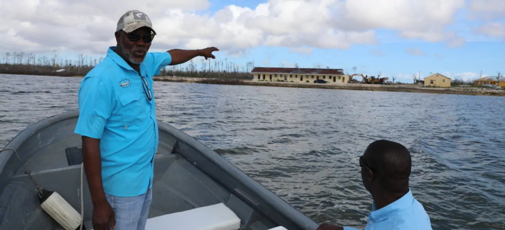 In February 2020, six months after the storm, Phil Thomas, left, points to a local school that was badly damaged by Hurricane Dorian. Photo: David Common / CBC