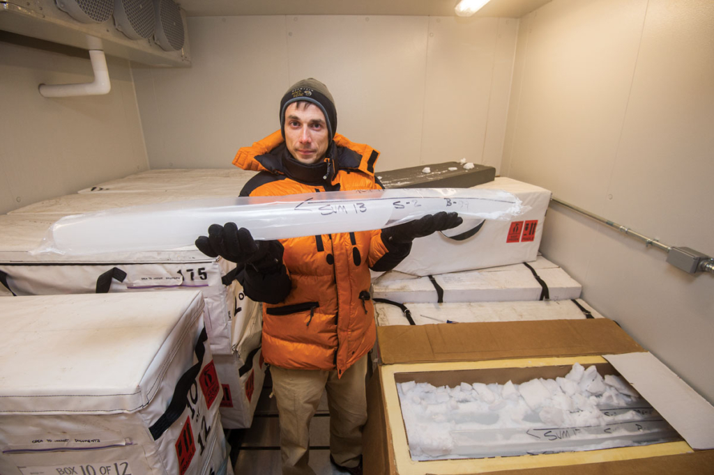 University of Rochester Earth and Environmental Sciences department assistant professor Vasilii Petrenko holds samples in his ice lab in Hutchison Hall, 23 July 2013. In a separate lab, PhD student Ben Hmiel sets up a gas line detector. Photo: J. Adam Fenster / University of Rochester