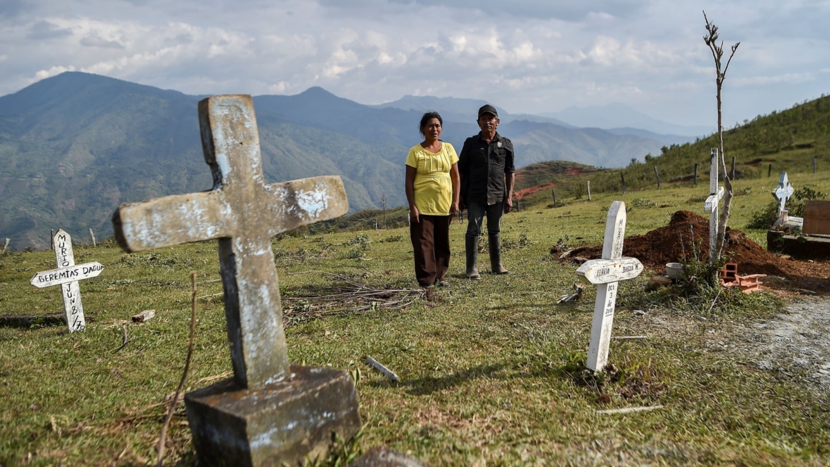 A woman and a man stand in a cemetery in Colombia. Three people have died and there are 277 cases in Colombia on 23 March 2020, as the local authorities impose restrictions. Death squads in Colombia are taking advantage of coronavirus lockdowns to murder rural activists, local NGOs have warned. Photo: Luis Robayo / AFP / Getty Images