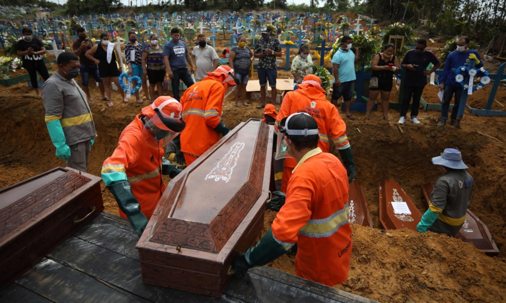 Gravediggers carry a coffin during a collective burial of people who have died due to Covid-19, at the Parque Tarumã cemetery in Manaus on 28 April 2020. Photo: Bruno Kelly / Reuters