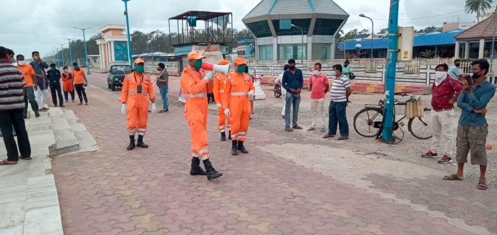 India’s National Disaster Response Force personnel warn people on the Bay of Bengal coast about Cyclone Amphan at Namkhana, South 24 Parganas, West Bengal, India on Tuesday, 19 May 2020. Photo: National Disaster Response Force / AP