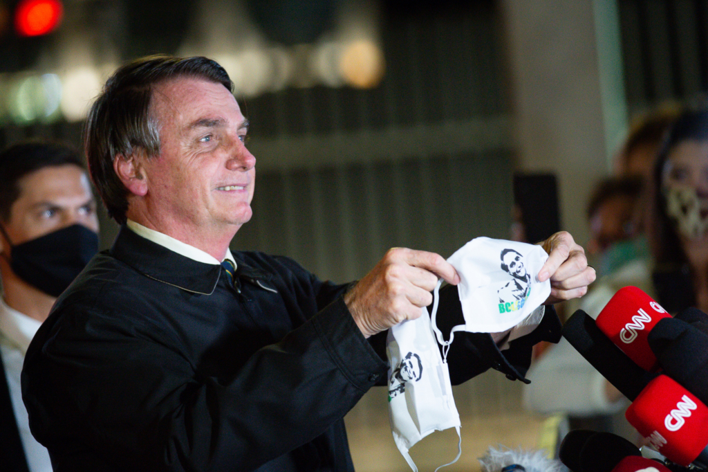 President of Brazil Jair Bolsonaro is pictured on 22 May 2020 in Brasilia, holding a coronavirus mask printed with his image. Photo: Andressa Anholete / Getty Images