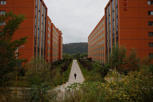 A man walks between newly built apartment blocks at Huateng’s Yadian coal mine near Xianyang, Bin County, Shaanxi province, China, on 30 September 2020. Photo: Thomas Peter / Reuters