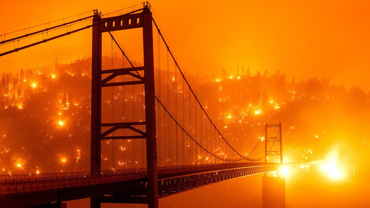 Wildfires light up a hillside behind the Bidwell Bar Bridge on 9 September 2020, as the Bear Fire burns in Oroville, California, in this photo taken with a slow shutter speed. Photo: Noah Berger / AP Photo