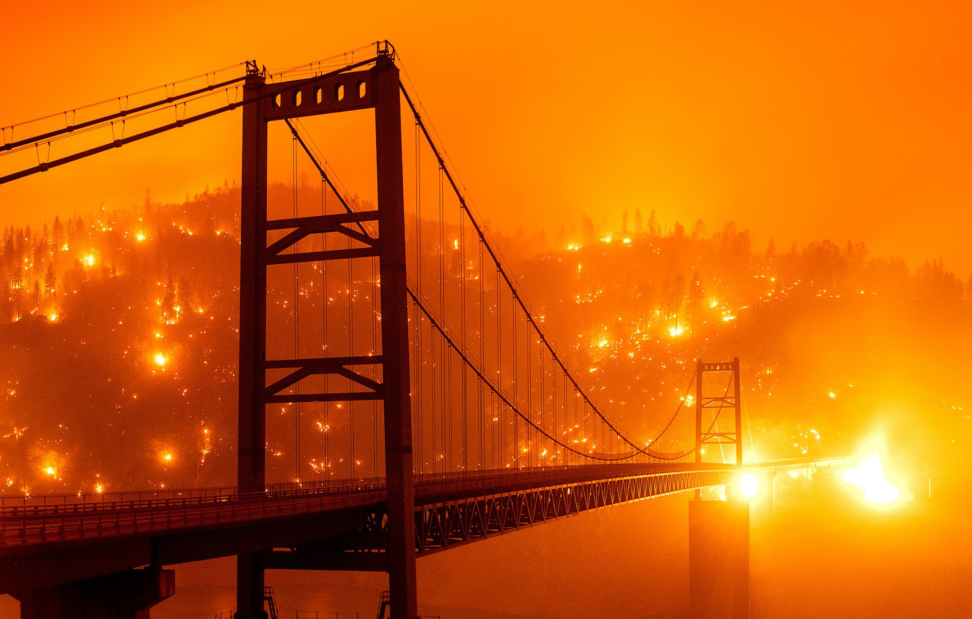 Wildfires light up a hillside behind the Bidwell Bar Bridge on 9 September 2020, as the Bear Fire burns in Oroville, California, in this photo taken with a slow shutter speed. Photo: Noah Berger / AP Photo