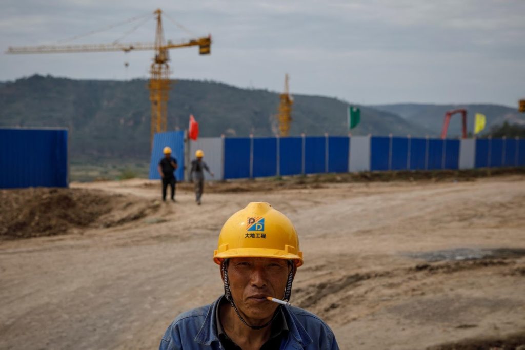 A worker stands outside a construction site of the Xinzhuang coal mine that is part of Huaneng Group’s integrated coal power project, on 30 September 2020. Photo: Thomas Peter / Reuters