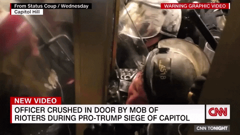 A Capitol Police officer is trapped in a door as Trump insurrectionists attack police inside the U.S. Capitol Building on 6 January 2021, in an attempt to stop the transfer of power from the Republican party to the Democrats. Video: Jon Farina / CNN