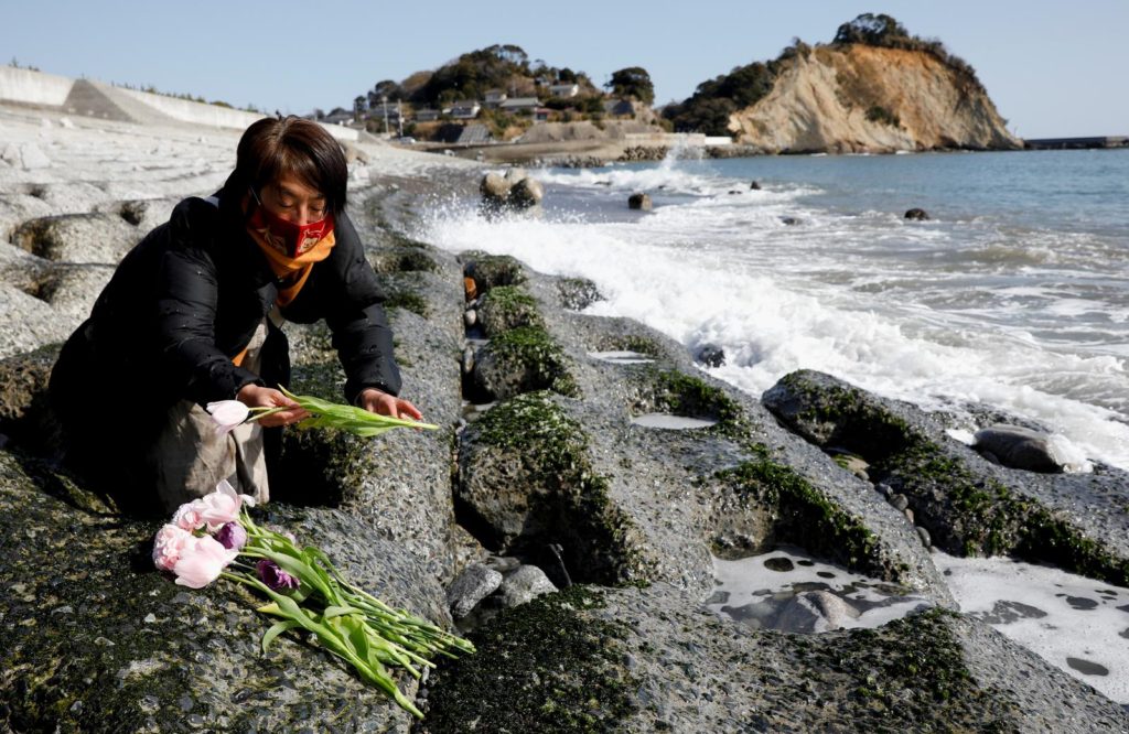 Mariko Odawara places flowers to mourn the victims of the earthquake and tsunami that killed thousands and triggered the worst nuclear accident since Chernobyl, during its 10th anniversary, in Iwaki, Fukushima prefecture, Japan, 10 March 2021. Photo: Kim Kyung-Hoon / REUTERS