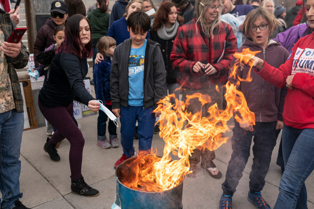 A protester tosses a mask into the fire during a mask burning event at the Idaho Statehouse in Boise, Idaho on 6 March 2021. Photo: Nathan Howard / Getty Images