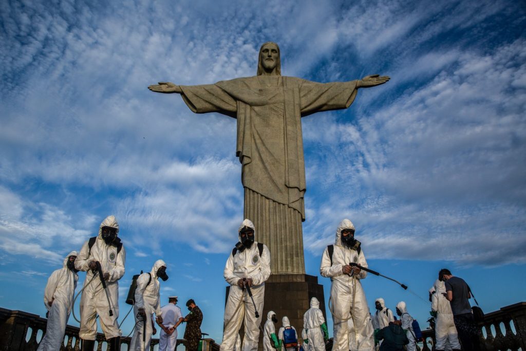 Workers in decontamination suits spray down the deck around the “Christ the Redeemer” statue in Rio de Janeiro, Brazil. Photo: Dado Galdieri / The New York Times