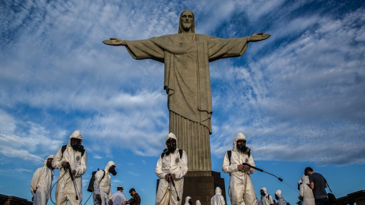 Workers in decontamination suits spray down the deck around the “Christ the Redeemer” statue in Rio de Janeiro, Brazil. Photo: Dado Galdieri / The New York Times