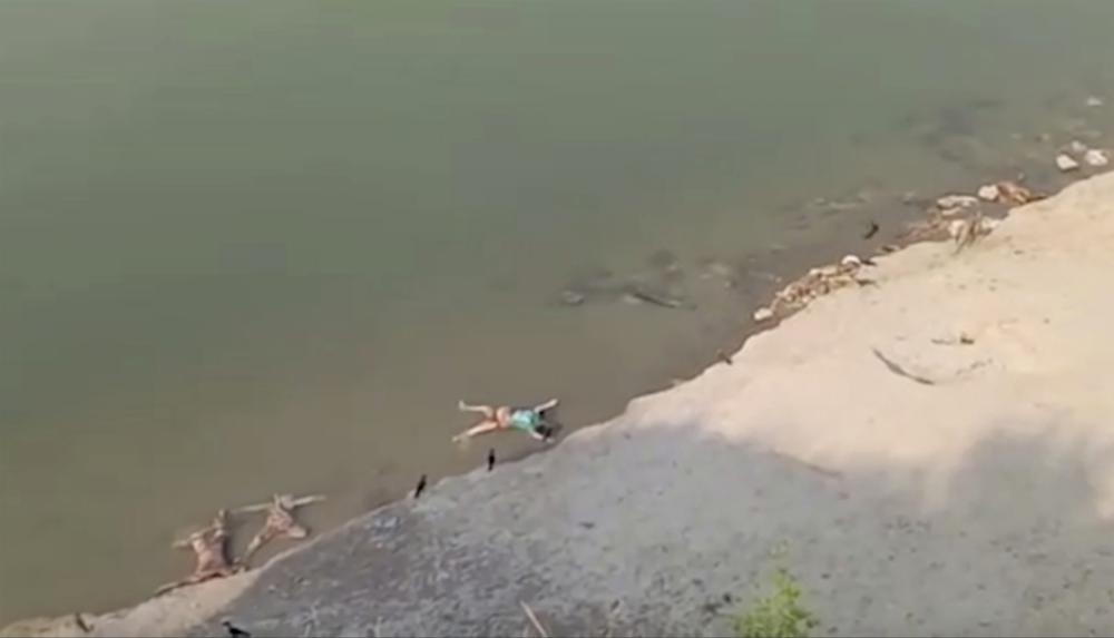 Bodies lie along Ganges river along the Ganges river in Ghazipur district in Uttar Pradesh state India, Tuesday, 11 May 2021. Scores of dead bodies have been found floating down the Ganges River in eastern India amid a ferocious surge in coronavirus infections in the country, but authorities said Tuesday they haven't been able to determine the cause of death. Health officials working through the night Monday retrieved 71 bodies, officials in Bihar state said. Photo: KK PRODUCTIONS / AP