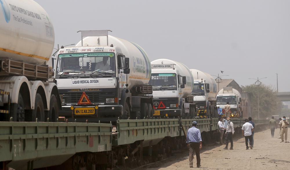 Empty tankers are loaded on a train wagon at the Kalamboli goods yard in Navi Mumbai, Maharashtra state, India, before they are transported to collect liquid medical oxygen from other states, Monday, 19 April 2021. The western Maharashtra state, which is worst hit by the coronavirus is facing a shortage of the gas used for the treatment of COVID-19 patients. India is being overrun by hundreds of thousands of new coronavirus cases, bringing a new reality for daily life in its main cities and towns. Photo: Rafiq Maqbool / AP Photo