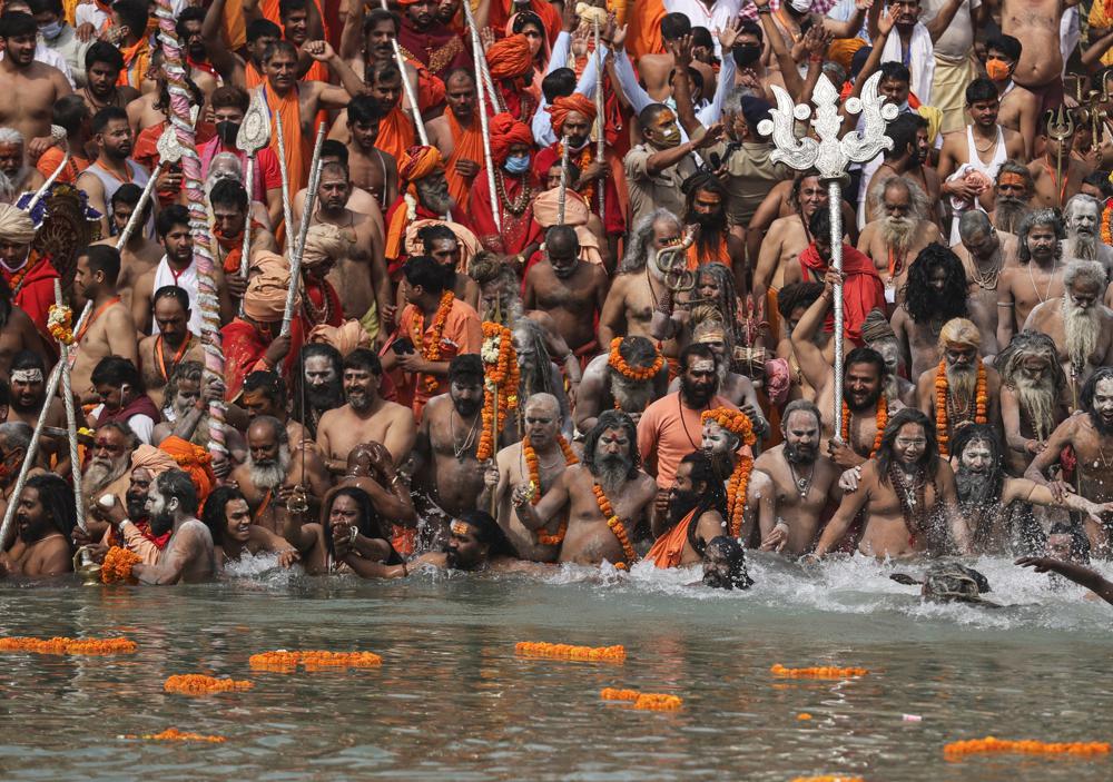 Naked Hindu holy men take holy dips in the Ganges River during Kumbh Mela, or pitcher festival, one of the most sacred pilgrimages in Hinduism, in Haridwar, northern state of Uttarakhand, India, Monday, 12 April 2021. They believe that a dip in holy water will wash away their sins and prevent rebirth. One prominent Hindu religious leader died of COVID-19. India has been overwhelmed by hundreds of thousands of new coronavirus cases daily, bringing pain, fear and agony to many lives as lockdowns have been placed in Delhi and other cities around the country. Photo: Karma Sonam / AP Photo