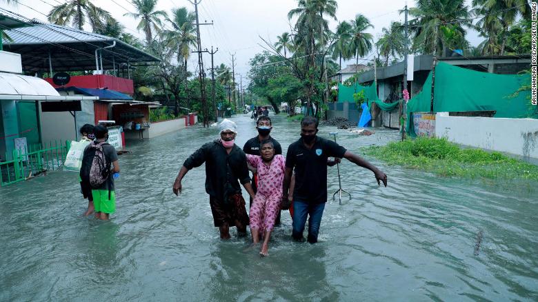 Police and rescue personnel evacuate a local resident through a street flooded by Cyclone Tauktae in a coastal area in Kochi, India on 14 May 2021. Photo: Arunchandra Bose / AFP / Getty Images