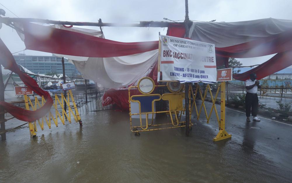 A security guard stands at the entrance of a vaccination center amid rain in Mumbai, India, Monday, 17 May 2021. Cyclone Tauktae, roaring in the Arabian Sea was moving toward India's western coast on Monday as authorities tried to evacuate hundreds of thousands of people and suspended COVID-19 vaccinations in one state. Photo: Rafiq Maqbool / AP Photo