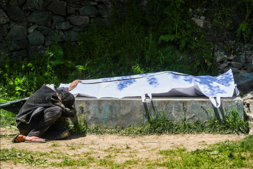 Umar Farooq mourns next to the body of his mother, who died of Covid-19, at a graveyard in Srinagar on 26 April 2021. Photo: Tauseef Mustafa / AFP / Getty Images