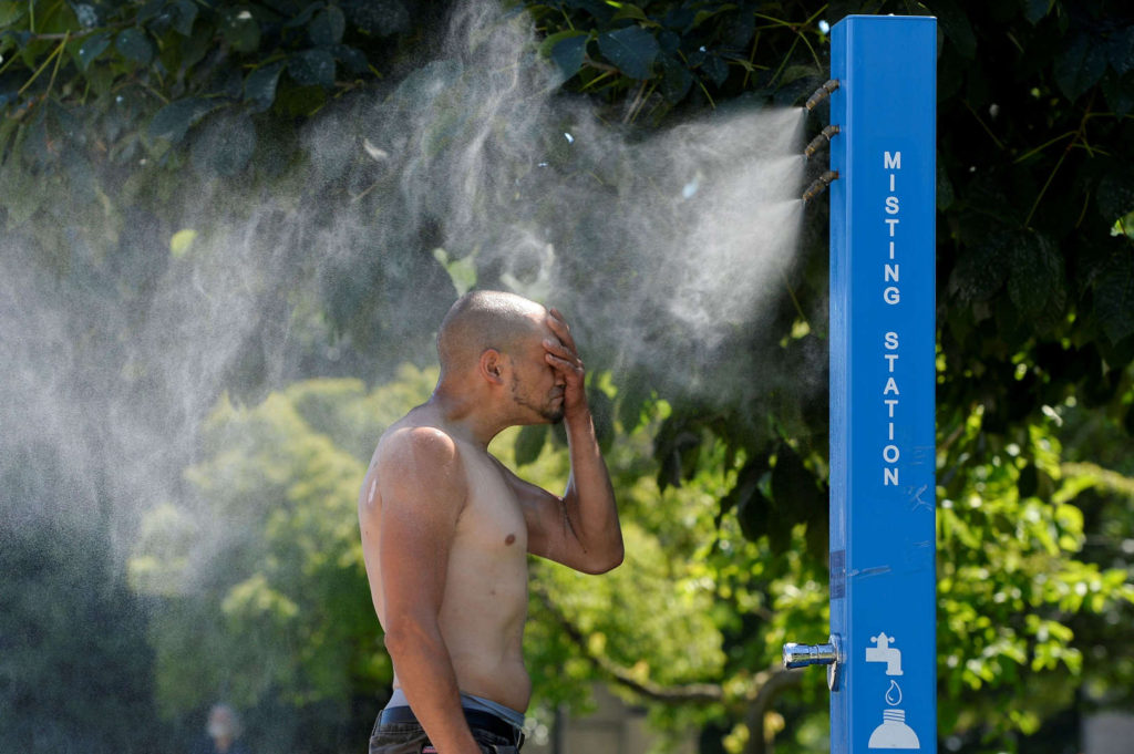 A man cools off at a misting station during the scorching weather of a record-breaking heatwave in Vancouver, British Columbia, 27 June 2021. Photo: Jennifer Gauthier / Reuters