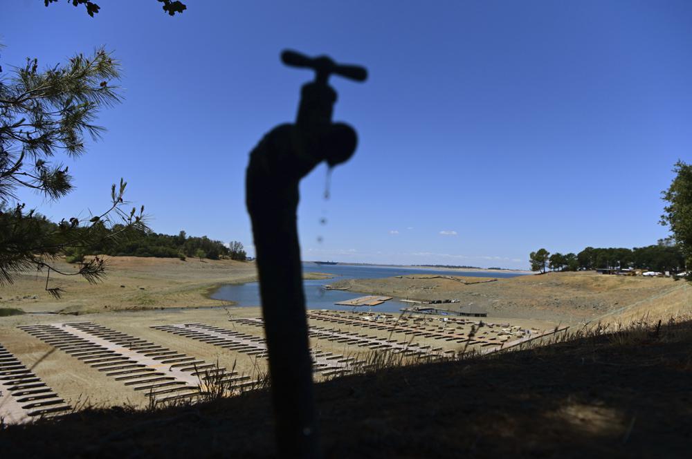 Water drips from a faucet near boat docks sitting on dry land at the Browns Ravine Cove area of drought-stricken Folsom Lake, currently at 37 percent of its normal capacity, in Folsom, California, on 22 May 2021. Photo: Josh Edelson / AP Photo