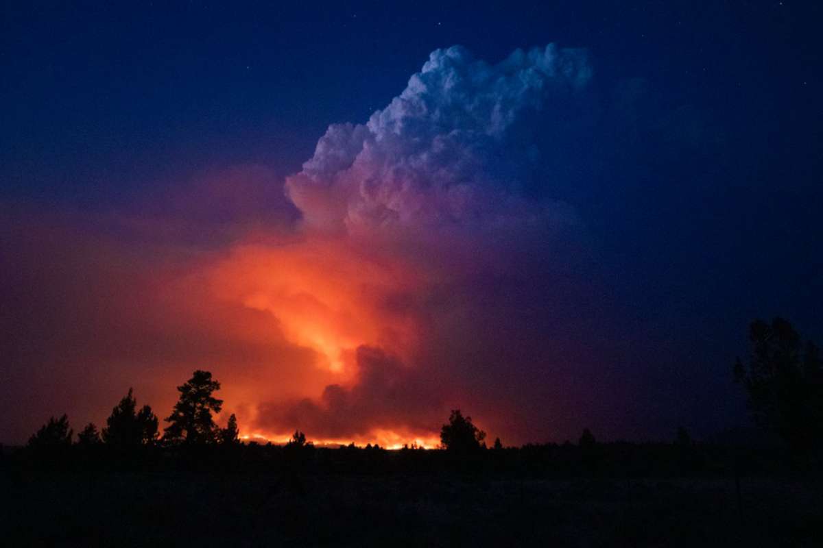 Flames and smoke rise from the Bootleg fire in southern Oregon on Wednesday, 14 July 2021. The largest fire in the U.S. on Wednesday was burning in southern Oregon, to the northeast of the wildfire that ravaged a tribal community less than a year ago. The lightning-caused Bootleg fire was encroaching on the traditional territory of the Klamath Tribes, which still have treaty rights to hunt and fish on the land, and sending huge, churning plumes of smoke into the sky visible for miles. Photo: John Hendricks / Oregon Office of State Fire Marshal / AP