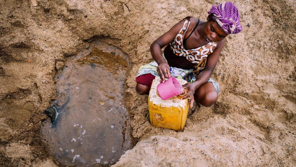 A woman collects water from a puddle in the dried Manambovo river bed in Tsihombe, Madagascar, 2 May 2021. Photo: Viviane Rakotoarivony / UN / REUTERS