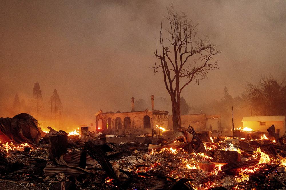 Buildings burn as the Dixie Fire tears through the Greenville community of Plumas County, California, on Wednesday, 4 August 2021. The fire leveled multiple historic buildings and dozens of homes in central Greenville. Photo: Noah Berger / AP Photo