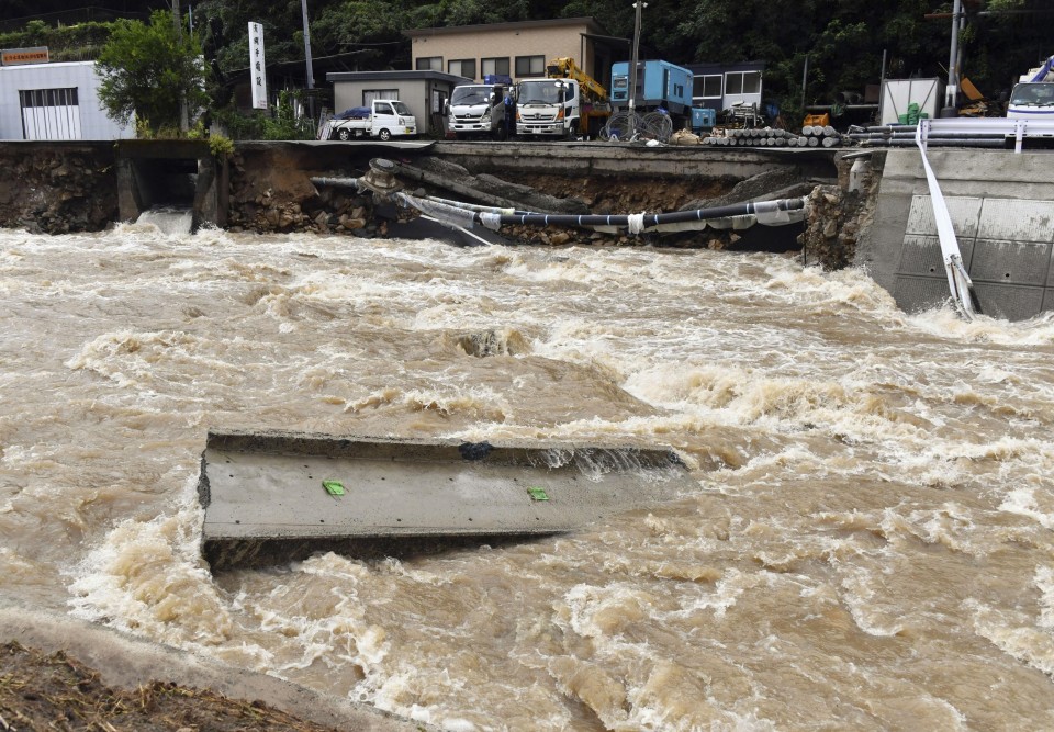 Record rain leaves a river swollen in Hiroshima on 13 August 2021, with a road alongside it partially washed away, as Japanese weather authorities issued warnings across wide areas of the country. Photo: Kyodo News