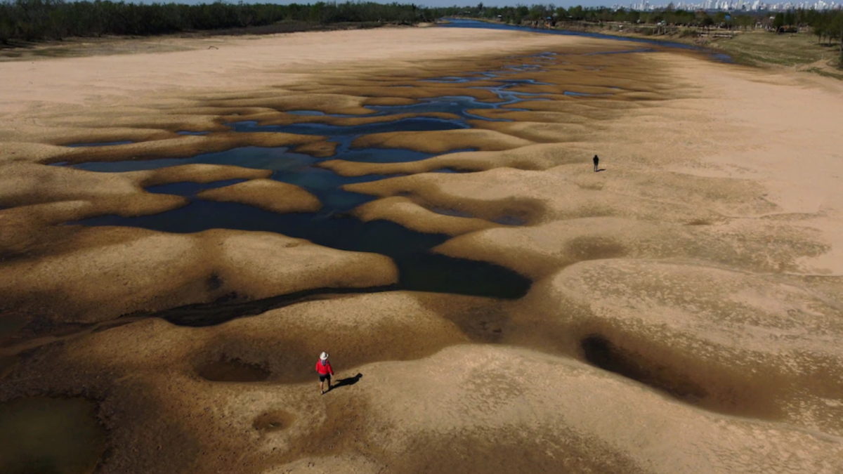 People walk along a dry arm of the Paraná River near Rosario, Argentina in 2021. Photo: Juan Mabromata / AFP / Getty Images