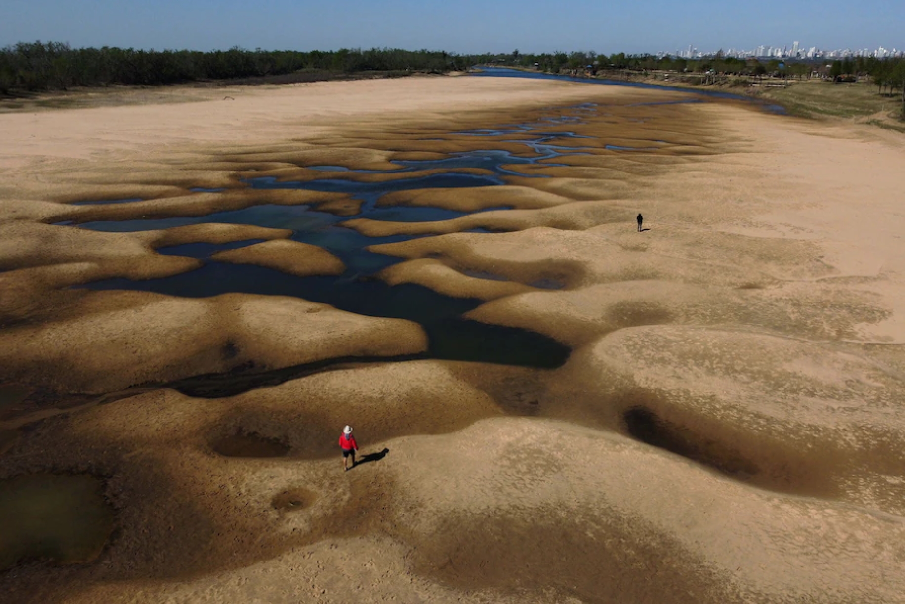 People walk along a dry arm of the Paraná River near Rosario, Argentina in 2021. Photo: Juan Mabromata / AFP / Getty Images