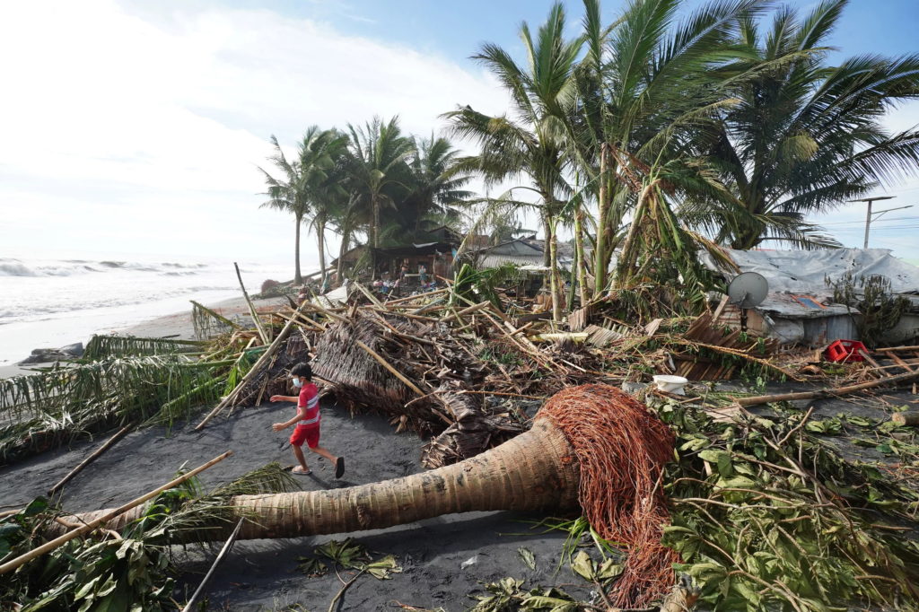 A child plays next to uprooted coconut and banana trees in the coastal town of Dulag in Leyte province, Philippines, on 17 December 2021, a day after Super Typhoon Rai hit. By Bobbie Alota / AFP / Getty Images