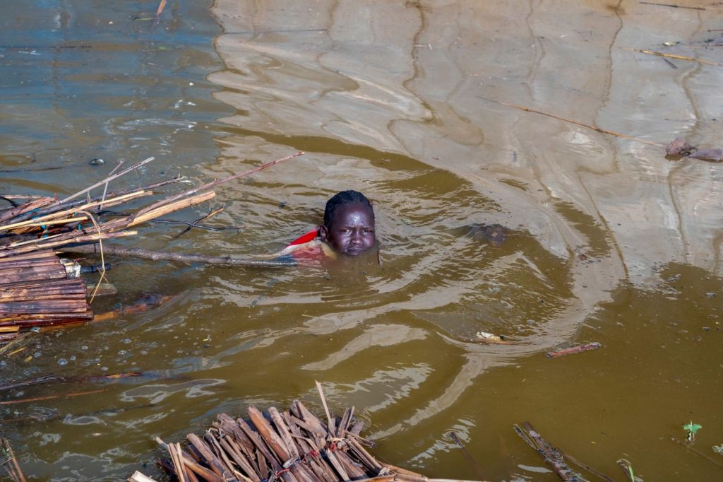 A girl pulls what remains of her family’s house through polluted floodwaters in South Sudan after record flooding in November 2021. Photo: Sebastian Rich / UNICEF