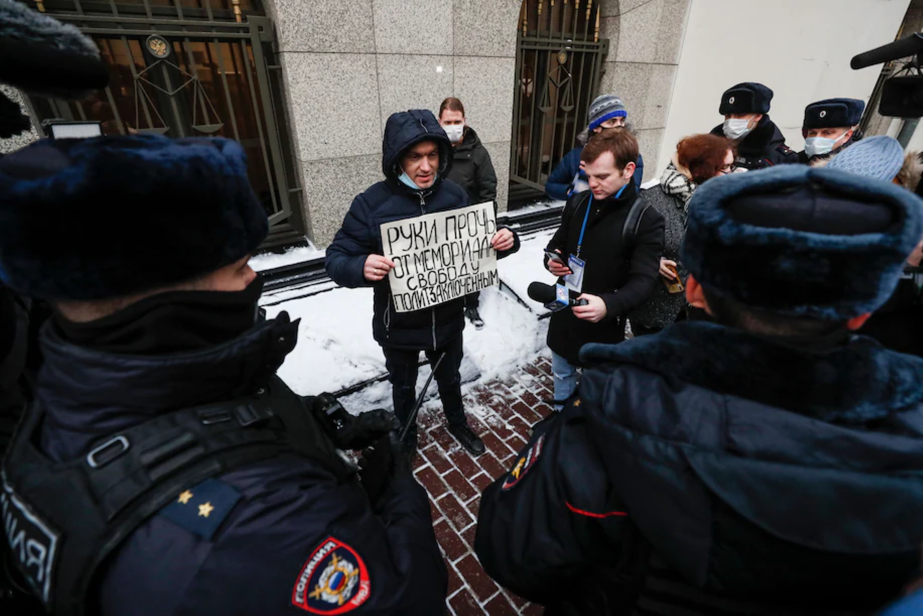 A supporter of Russia’s most prominent human rights organization, the International Memorial Society, holds a sign reading, “Hands off Memorial,” outside the Russian Supreme Court in Moscow on 28 December 2021. Russia’s Supreme Court ordered the liquidation of Memorial, in a decision that dismayed rights advocates. The ruling signaled the Kremlin’s determination to obliterate dissent, after a year in which authorities have jailed and harassed hundreds of opposition figures, activists, journalists and human rights lawyers, forcing dozens of them to flee the country. Photo: Yuri Kochetkov / EPA-EFE / Shutterstock