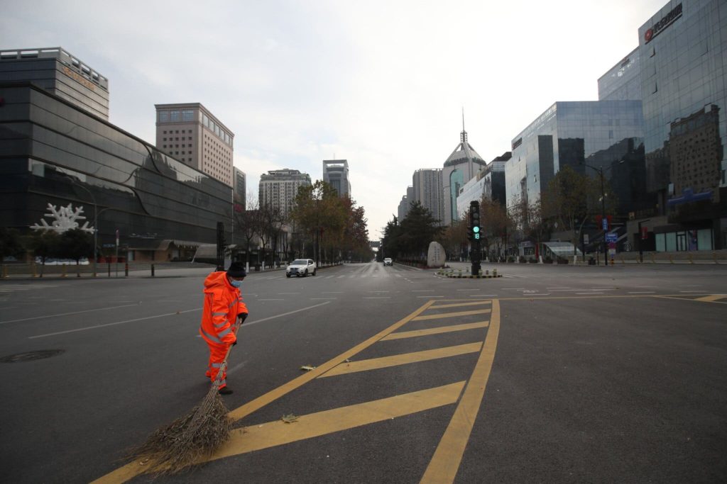 A sanitation worker sweeps a deserted road in Xi’an, in the northern Chinese province of Shaanxi, after the city was locked down in December 2021 due to COVID-19. Photo: Agence France-Presse / Getty Images