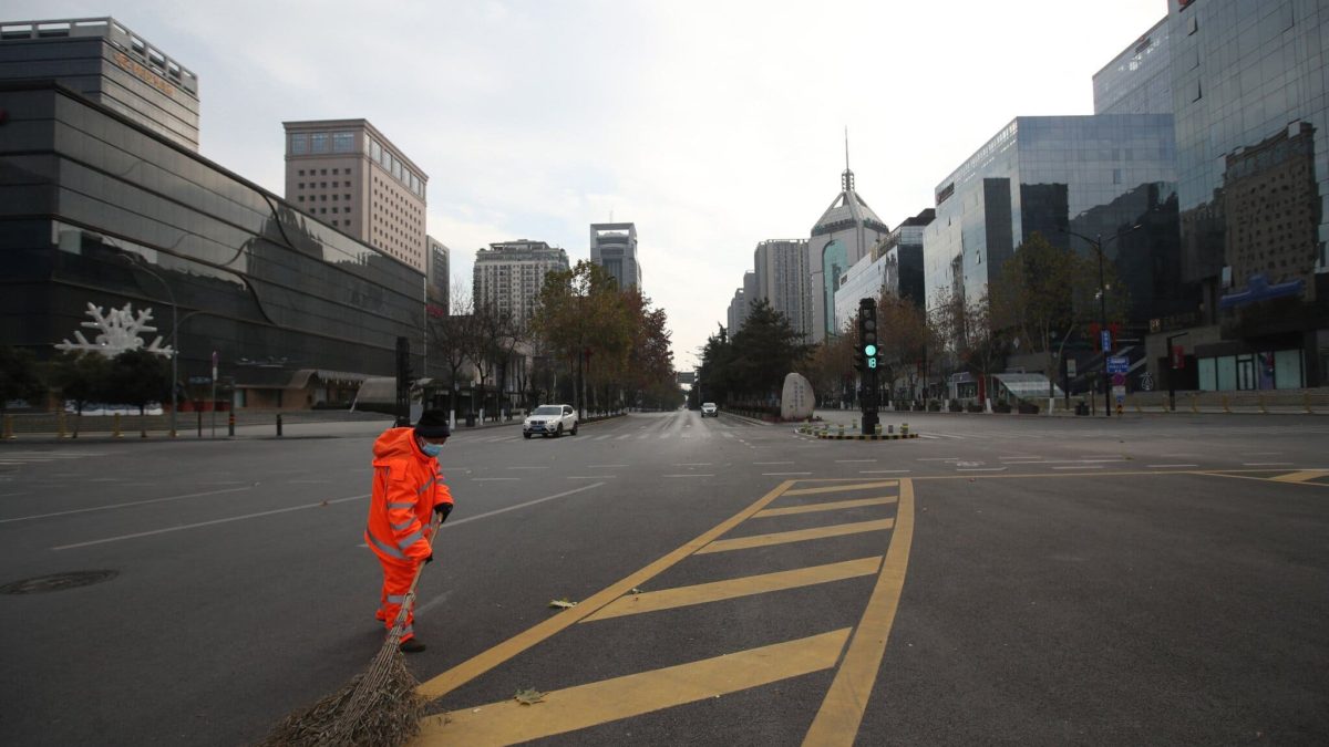 A sanitation worker sweeps a deserted road in Xi'an, in the northern Chinese province of Shaanxi, after the city was locked down in December 2021 due to COVID-19. Photo: Agence France-Presse / Getty Images