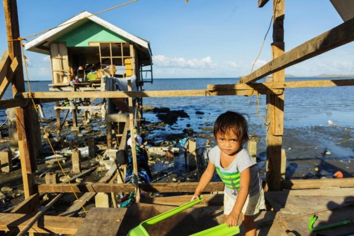 Gwendolyn, 2, stands in the house her family has already started rebuilding on 20 December 2021 after Super Typhoon Rai/Odette destroyed homes in Barangay Fatima, Purok 1 in Ubay, Bohol, Philippines. Almost all of the houses near the shore in this area were completely destroyed by Typhoon Rai/Odette. Photo: Hogsholt/ UNICEF / UN0570018
