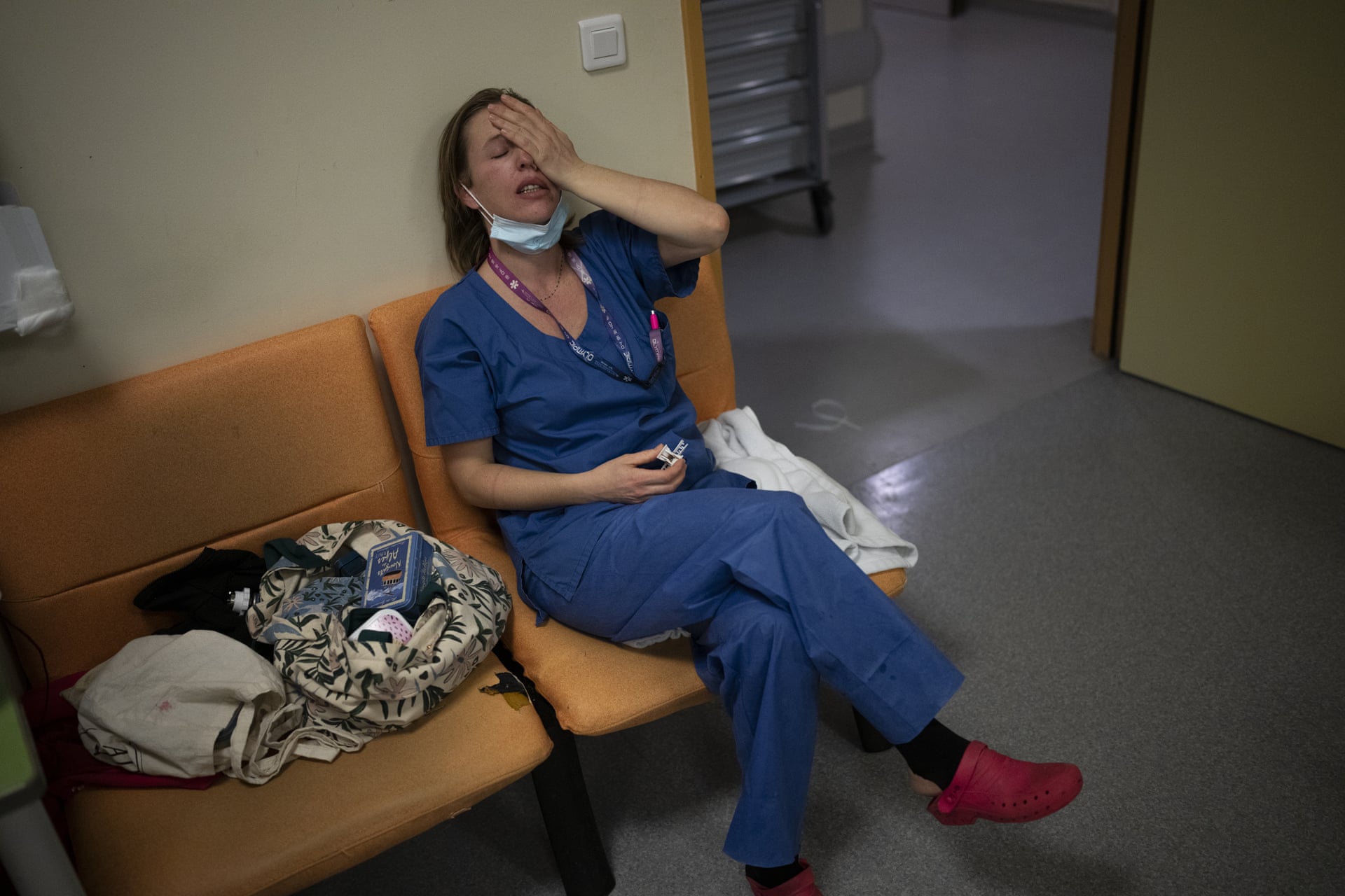 Nurse Marie-Laure Satta wipes her face during a pause in her New Year’s Eve shift in the COVID-19 intensive care unit at La Timone hospital in Marseille, France, 31 December 2021. Photo: Daniel Cole / AP Photo