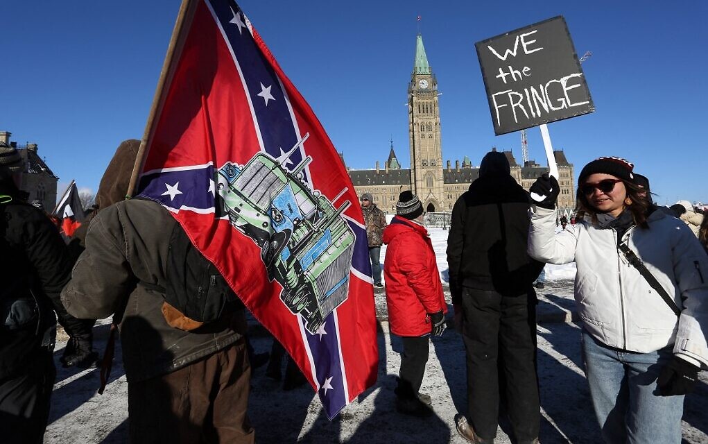 A protester carries a U.S. Confederate flag during the Freedom Convoy protest against COVID-19 vaccine mandates and restrictions, in front of the Canadian Parliament in Ottawa, on 29 January 2022. Photo: Dave Chan / AFP