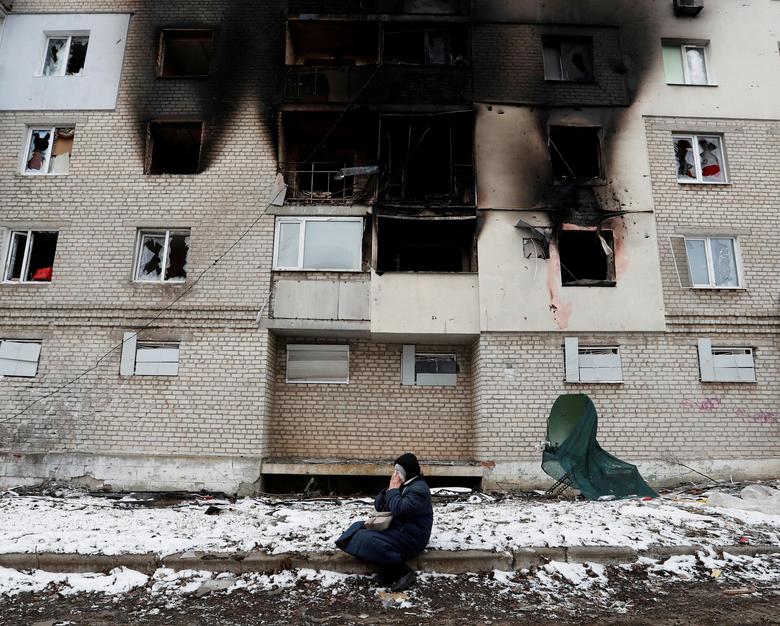 A woman weeps in front of a residential building that was damaged during the Russian invasion of Ukraine in the separatist-controlled town of Volnovakha in the Donetsk region, Ukraine, 11 March 2022. Alexander Ermochenko / REUTERS