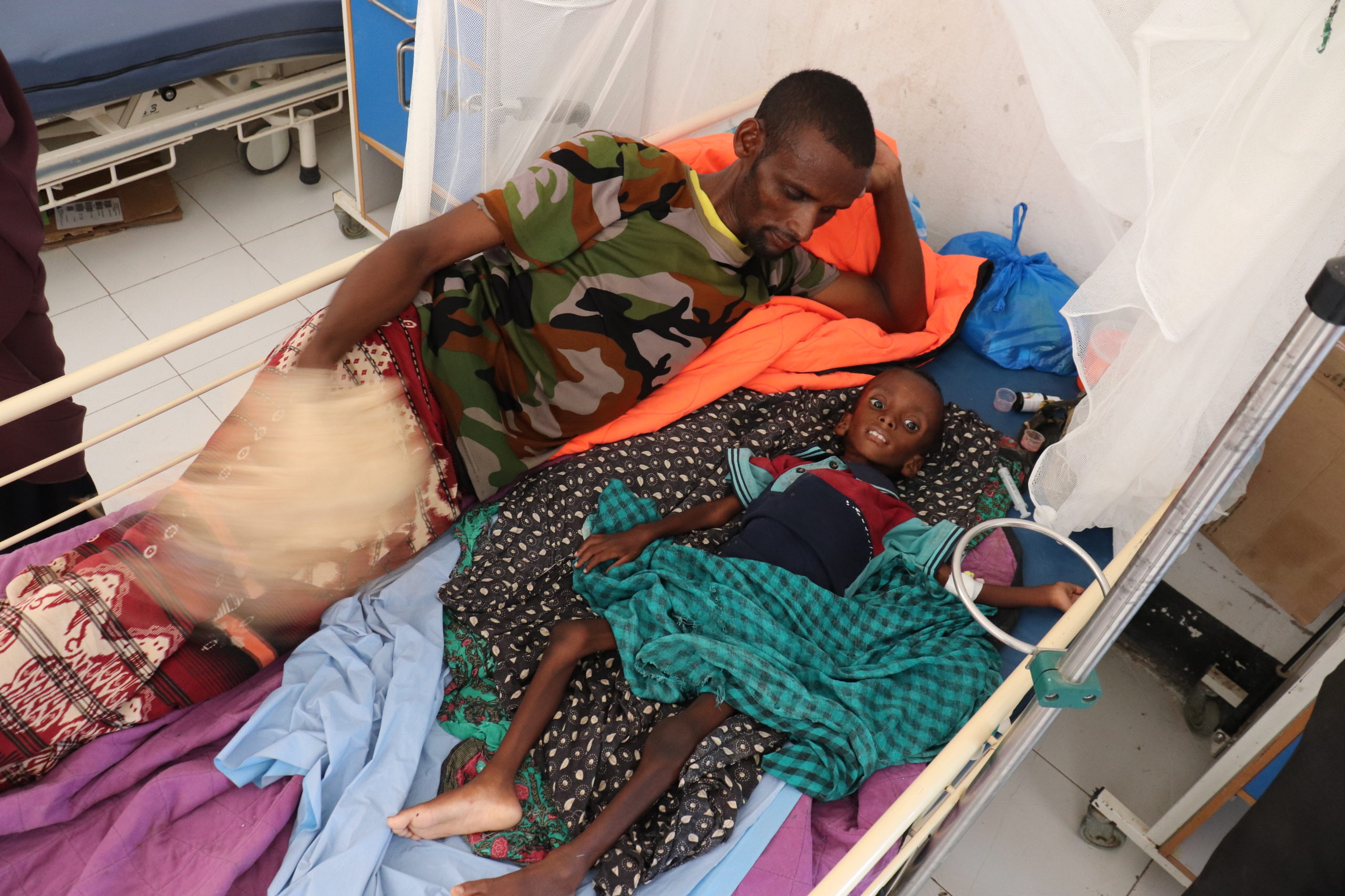 Abdullahi Mohamed and his son Adan at Baardheere district hospital in Baardheere, Jubaland, Somalia, where Adan is being treated for severe malnutrition, 13 March 2022. Photo: Petroc Wilton / WFP
