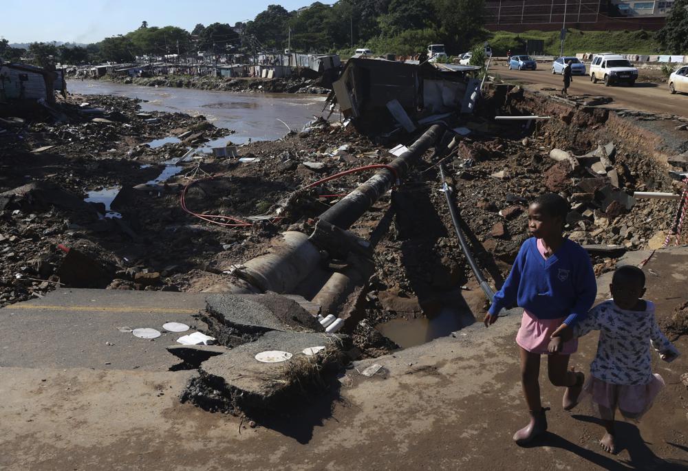 Children walk on a road damaged by record flooding at an informal settlement in Durban, South Africa, Thursday, April 14, 2022. The Heaviest rains and flooding in 60 years have killed at least 341 people in South Africa’s eastern KwaZulu-Natal province, including the city of Durban. Photo: AP Photo